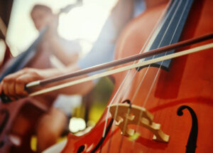 Cropped shot of an unrecognizable woman playing a cello outdoors